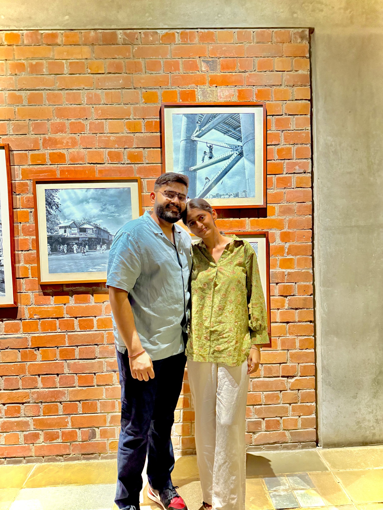 Dev and Dhimahi standing together beside a brick wall